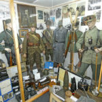 Overview of a museum showcase with military uniforms and exhibits from the Second World War