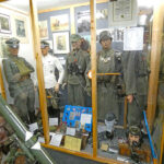 Überblick über eine Museumsvitrine mit Militäruniformen und Exponaten des Zweiten Weltkriegs