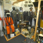 Bundeswehr-themed exhibition showing soldier uniforms, equipment, and a military workspace in a museum display