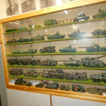 Bundeswehr-themed exhibition showing soldier uniforms, equipment, and a military workspace in a museum display