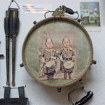 Historical children’s drum with a photograph of two children in military-style clothing from the German Empire period